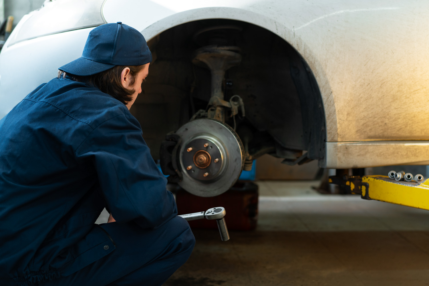 Mechanik wykonujący naprawę samochodu w warsztacie